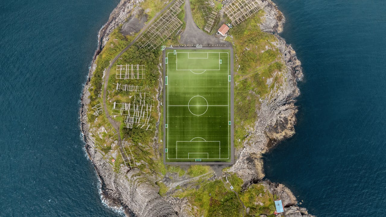 Stunning aerial view of the Henningsvær soccer field surrounded by the sea in Norway.